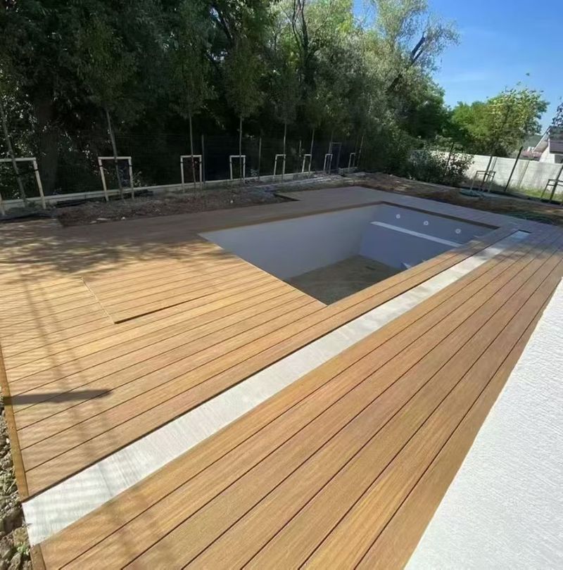 Golden teak composite decking wrapping a new in-ground pool